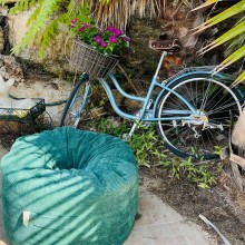 קמילה קורדורוי ירוק בגינה ליד האופניים